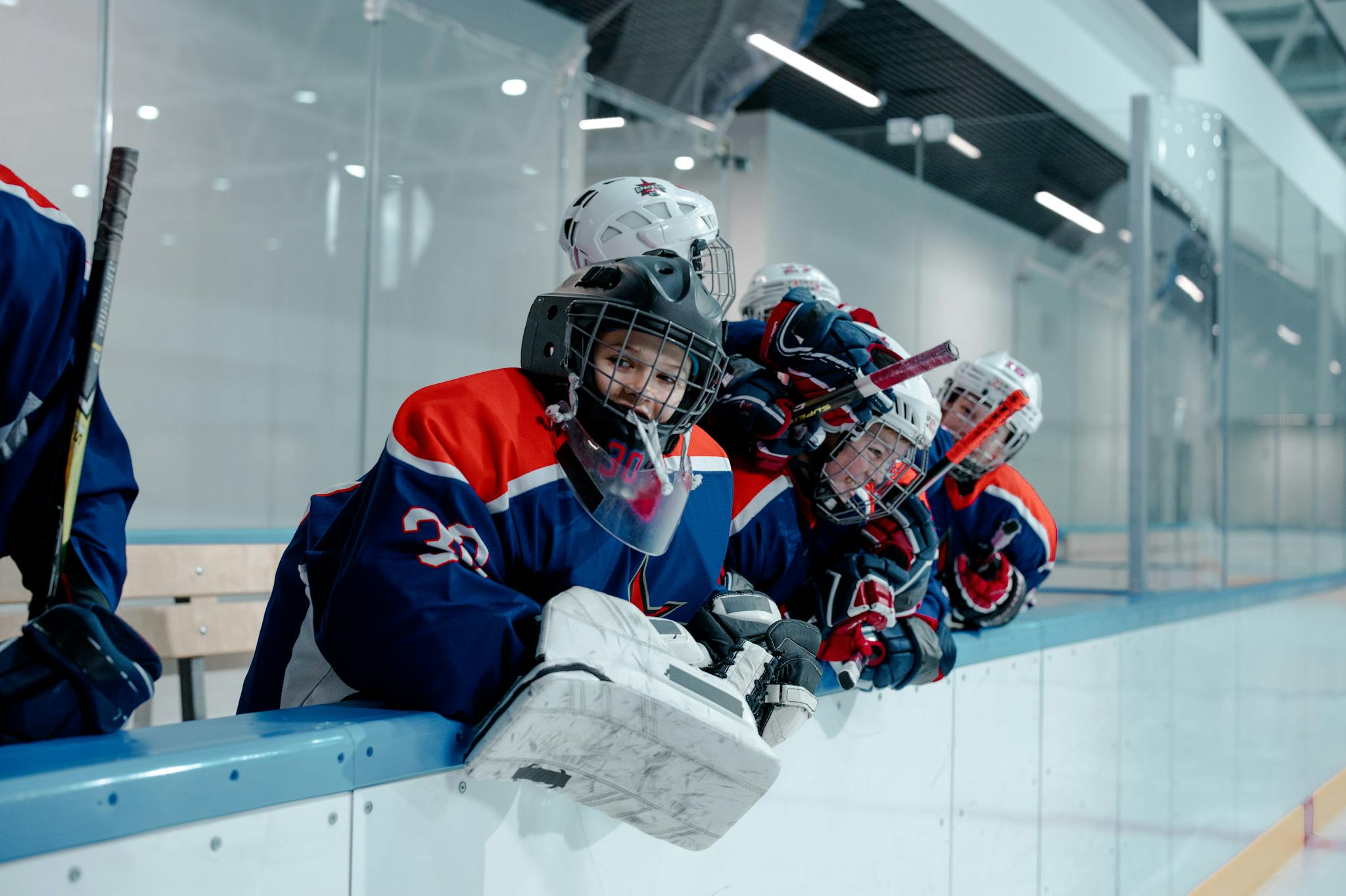 Excited youth ice hockey team celebrating a victory at an indoor arena.